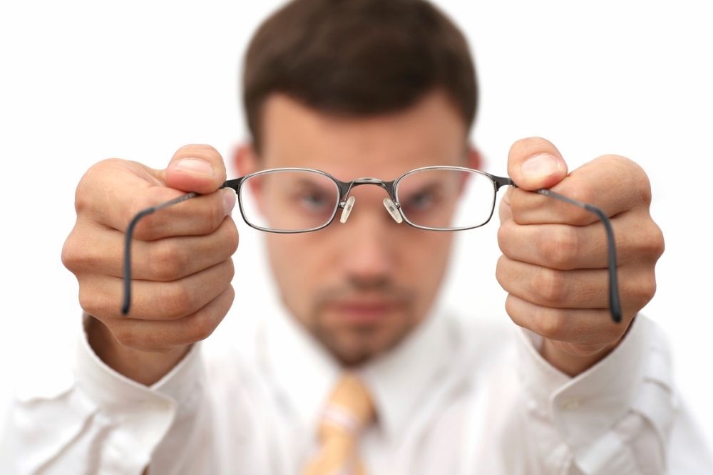 man holding eyeglasses with two hands