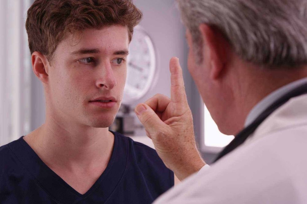 man tracking doctors finger for eye test